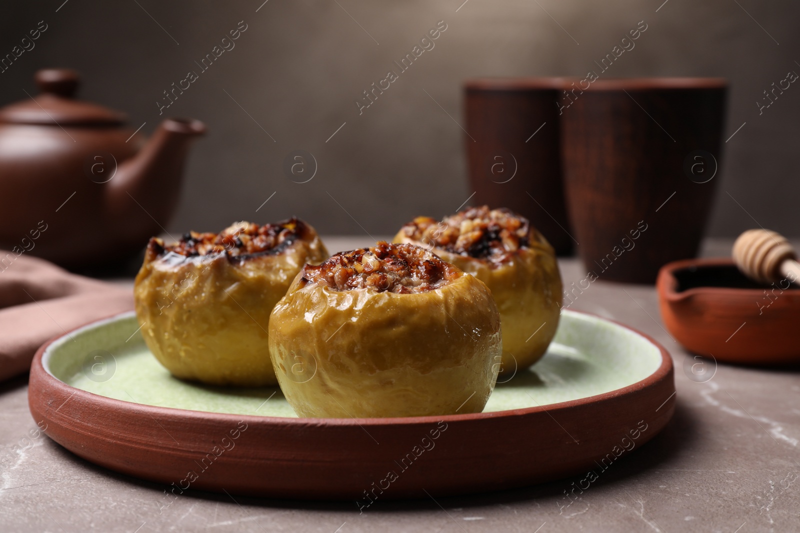 Photo of Baked apples with delicious filling served on grey table