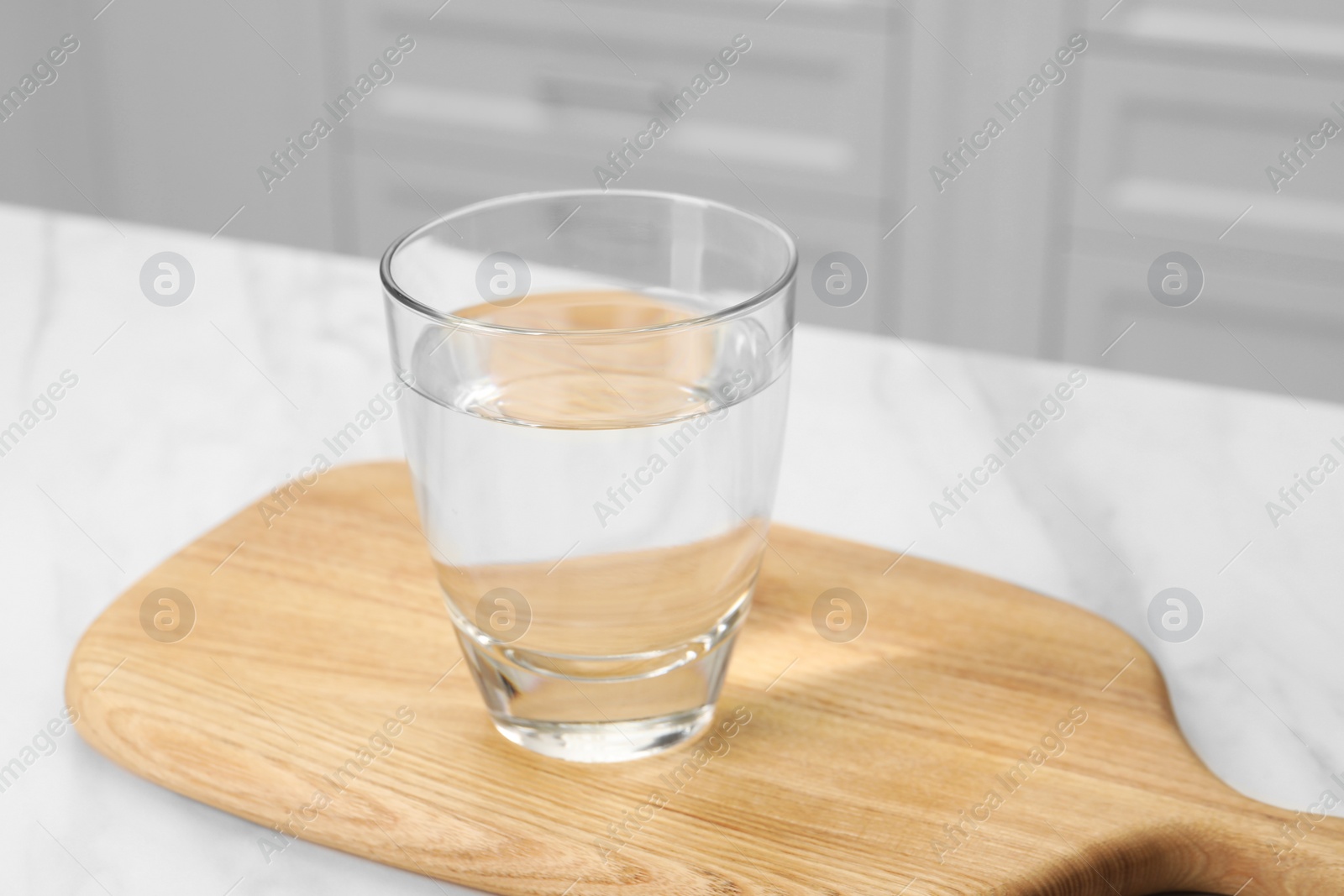 Photo of Filtered water in glass on white table indoors, closeup