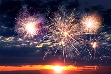 Image of Beautiful bright fireworks lighting up twilight sky outdoors