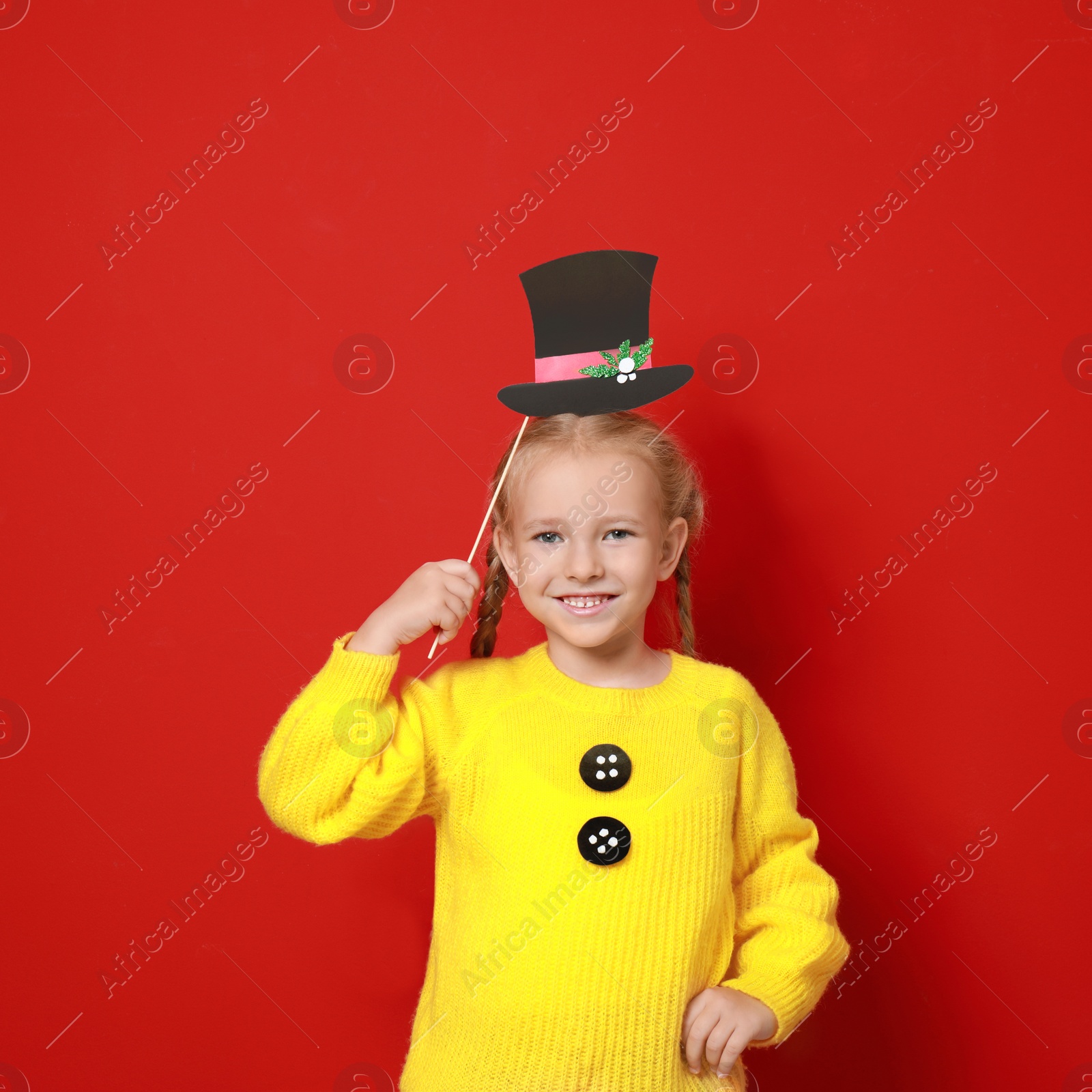 Image of Cute little girl with Christmas hat prop on red background