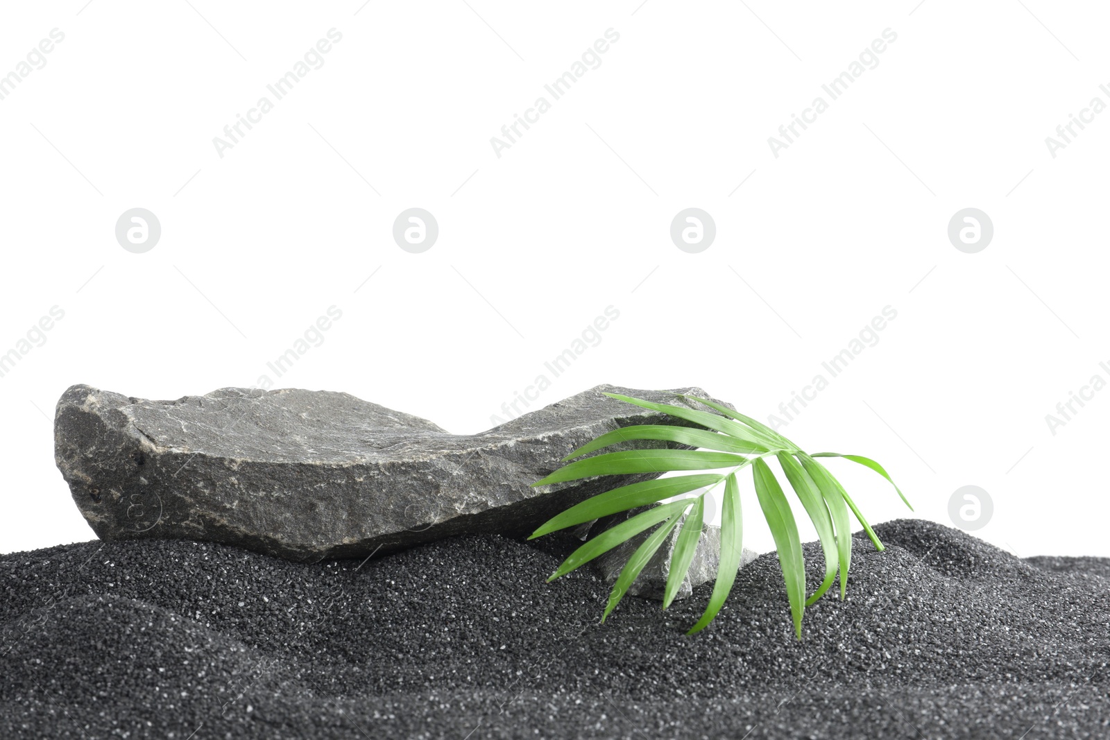 Photo of Presentation of product. Stone podium and palm leaves on black sand against white background