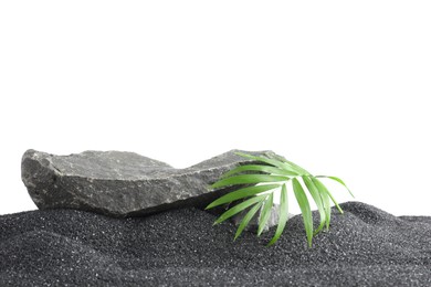 Photo of Presentation of product. Stone podium and palm leaves on black sand against white background