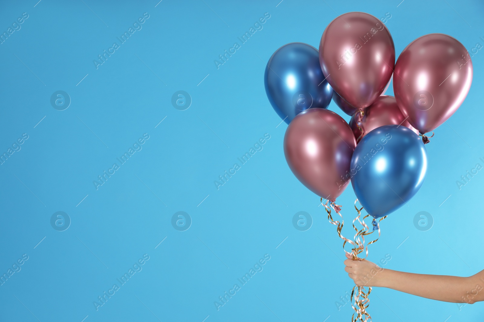 Photo of Woman holding bunch of balloons on color background, closeup. Space for text