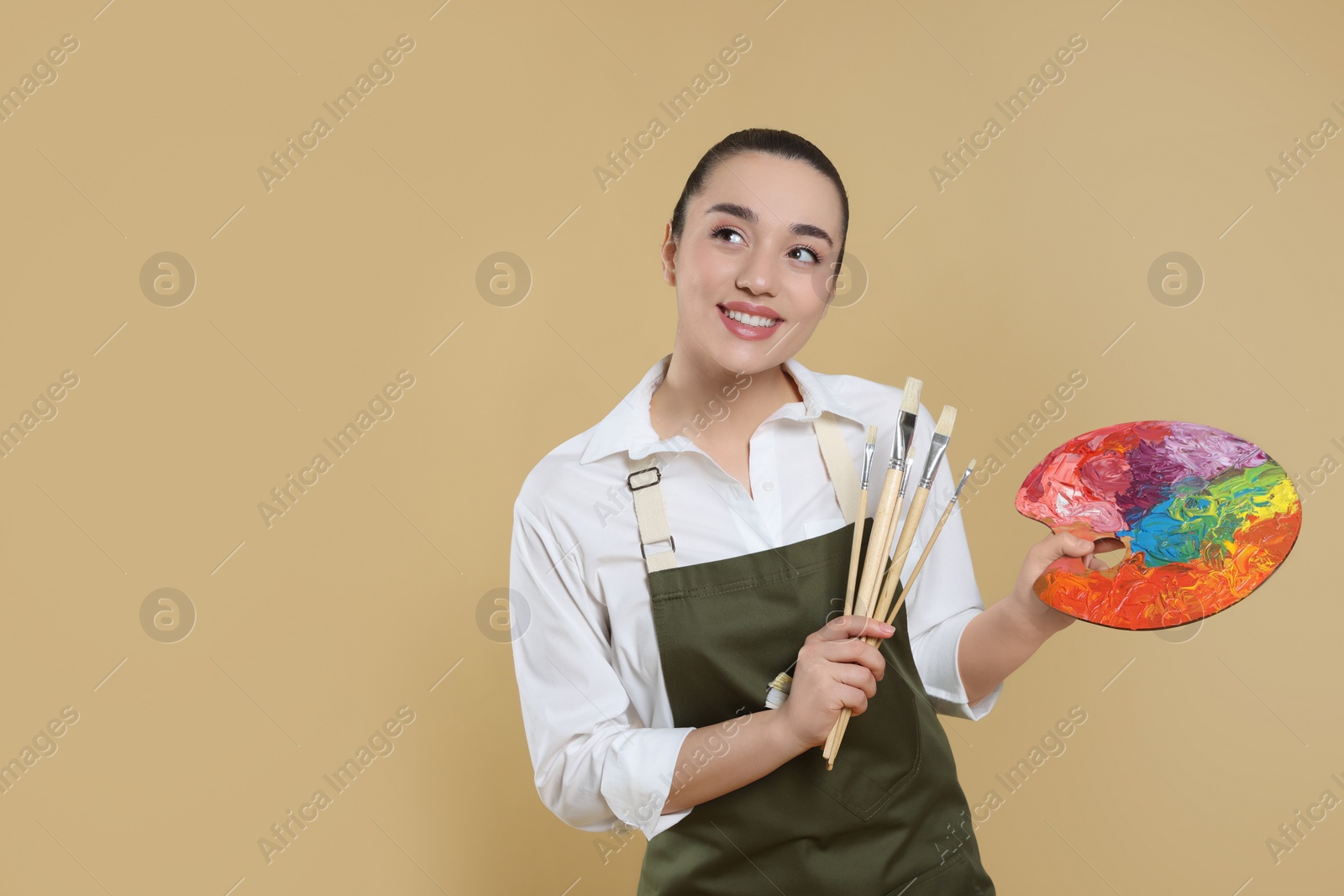 Photo of Woman with painting tools on beige background, space for text. Young artist