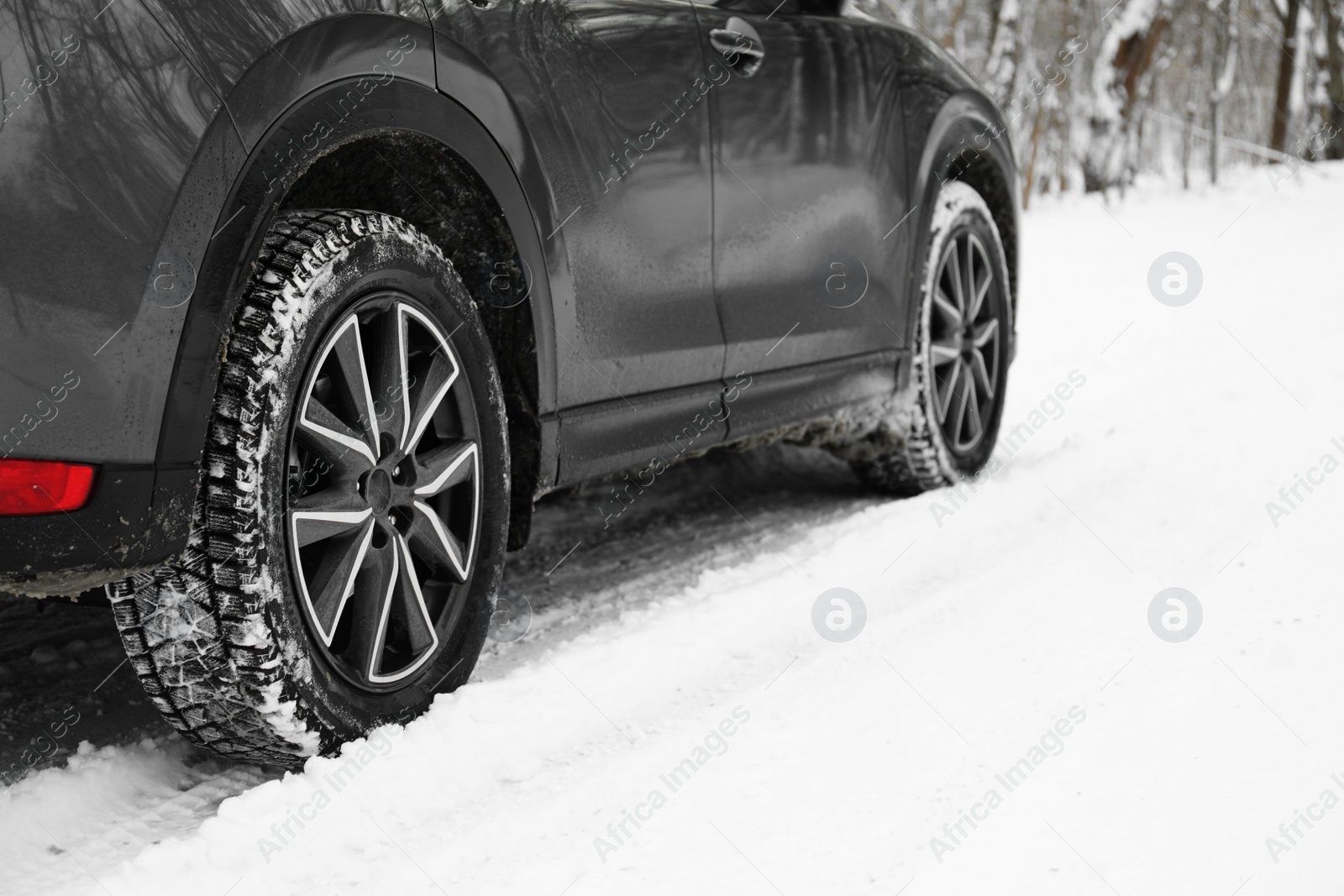 Photo of Snowy country road with car on winter day