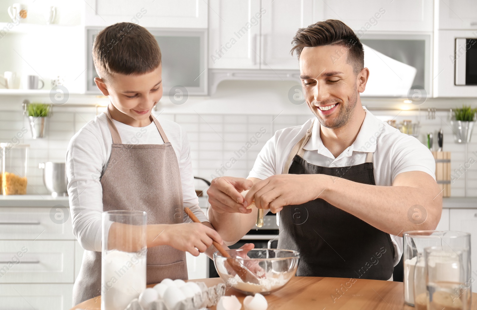 Photo of Dad and son cooking together in kitchen