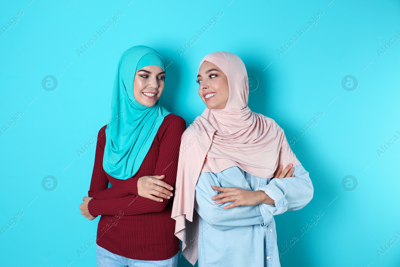 Photo of Portrait of young Muslim women in hijabs against color background