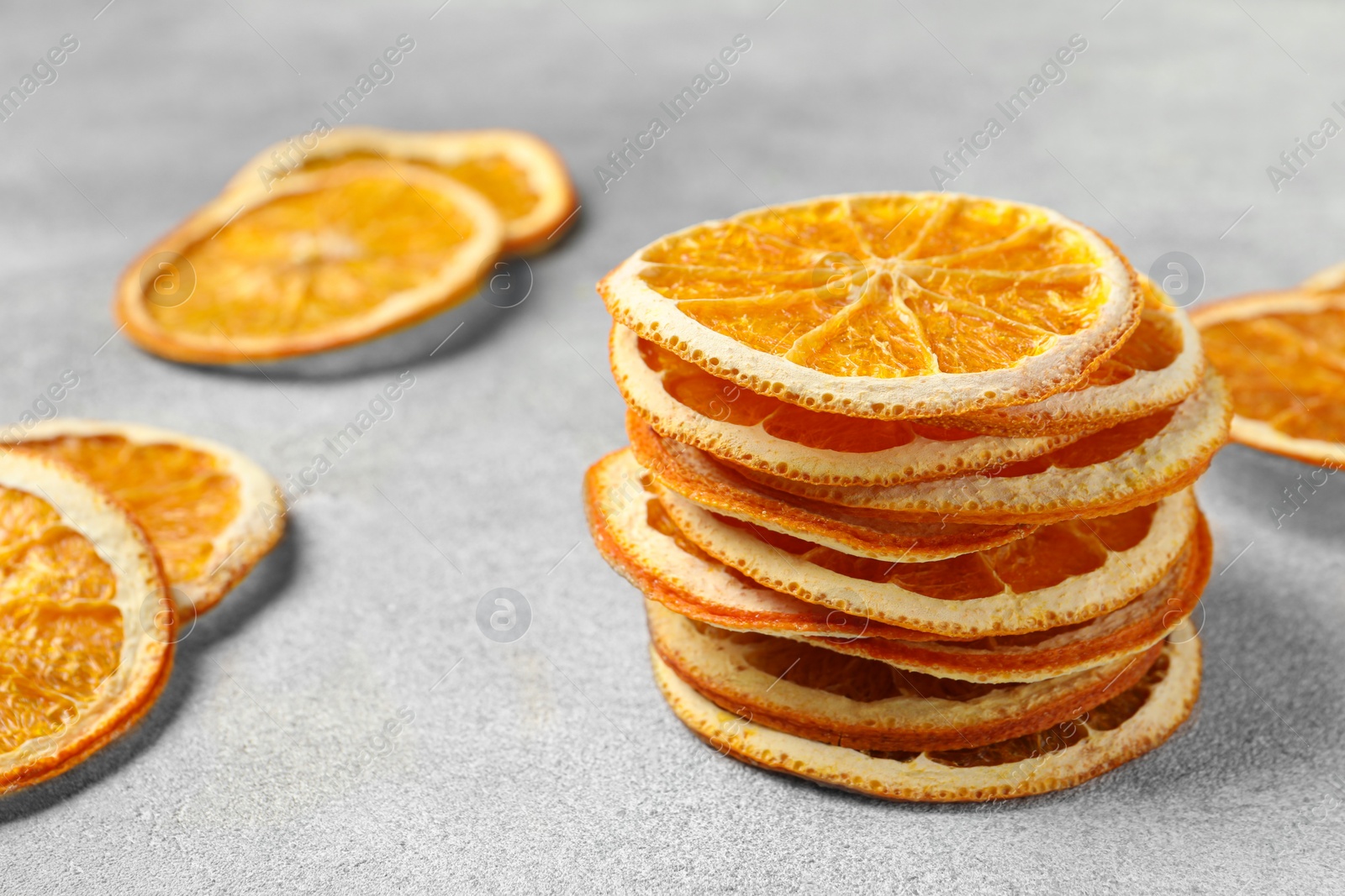Photo of Dry orange slices on light grey table, space for text
