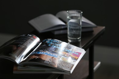 Photo of Open sports magazine on table in dark room