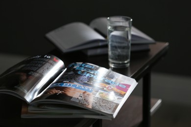 Open sports magazine on table in dark room