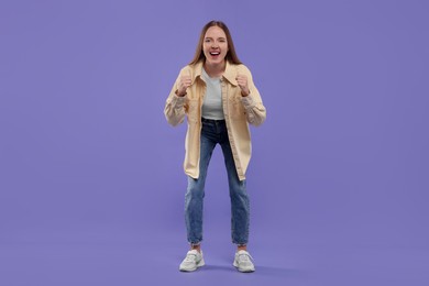 Photo of Emotional sports fan celebrating on purple background