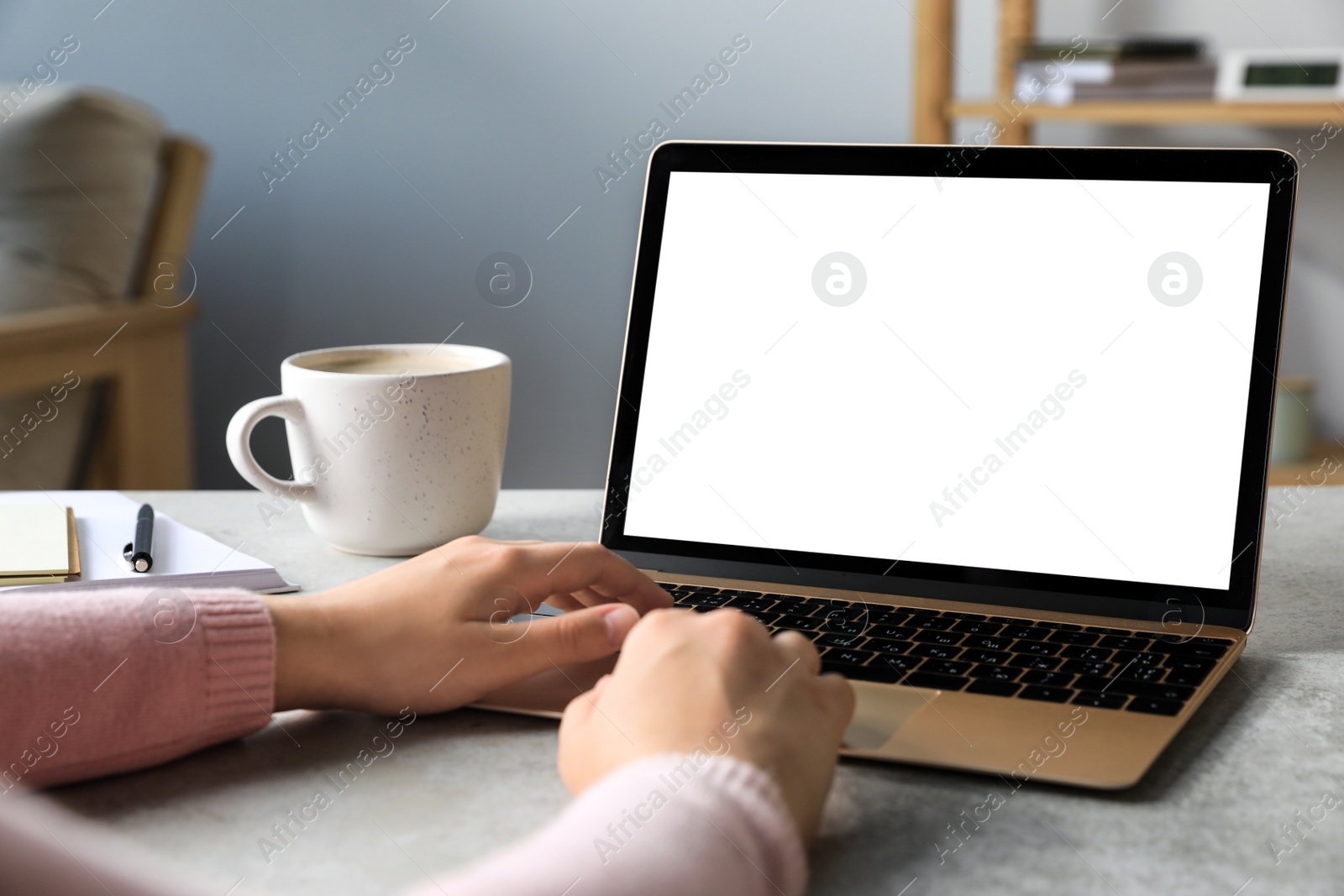 Photo of Woman working on laptop at white table, closeup. Mockup for design