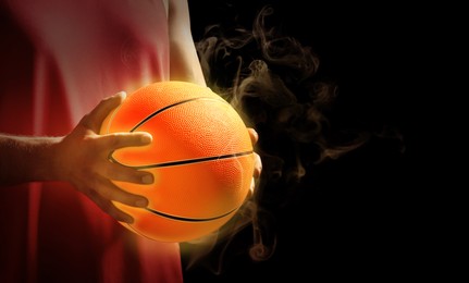 Basketball player with hot ball on black background, closeup. Space for text