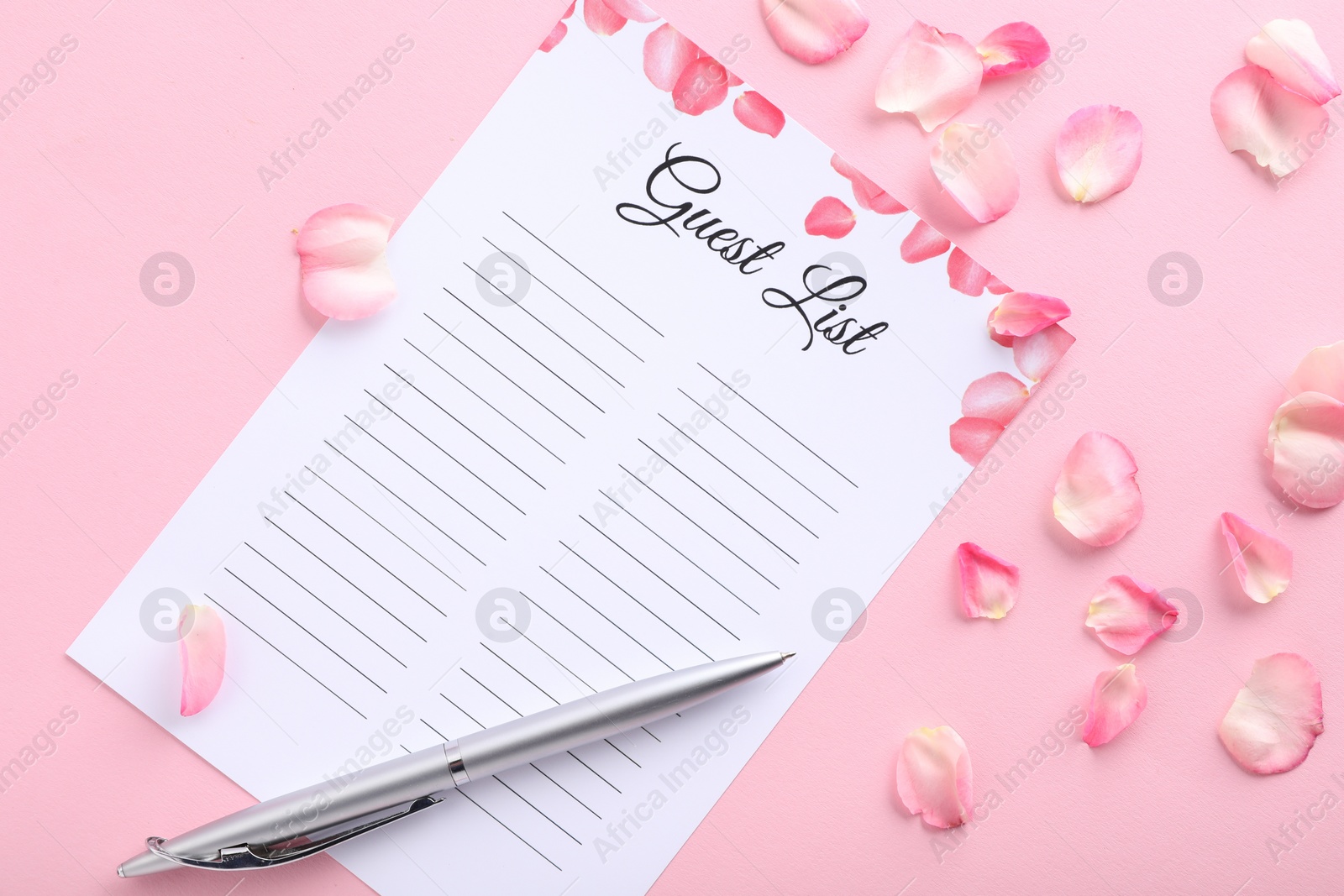 Photo of Guest list, pen and petals on pink background, flat lay. Space for text