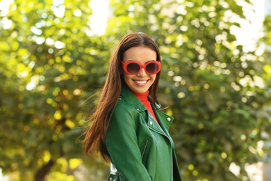 Photo of Beautiful woman wearing red sunglasses in green park