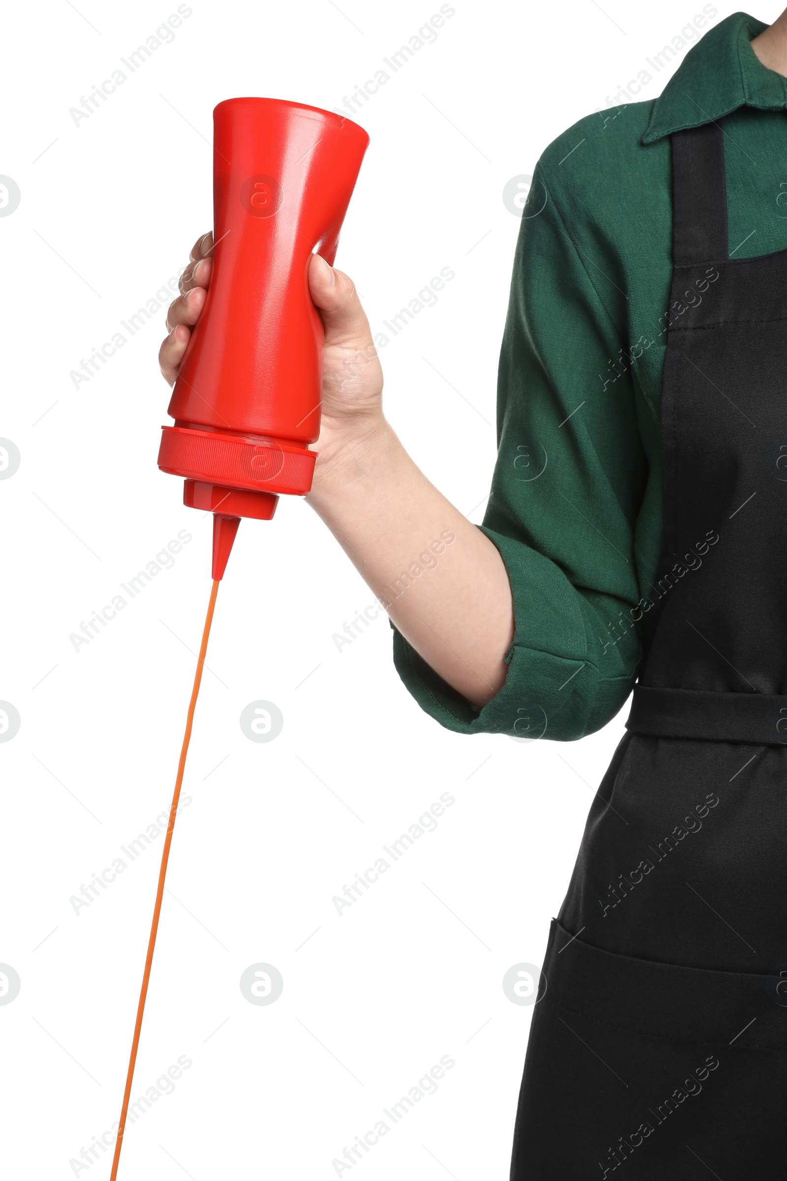 Photo of Woman pouring tasty ketchup from bottle on white background, closeup