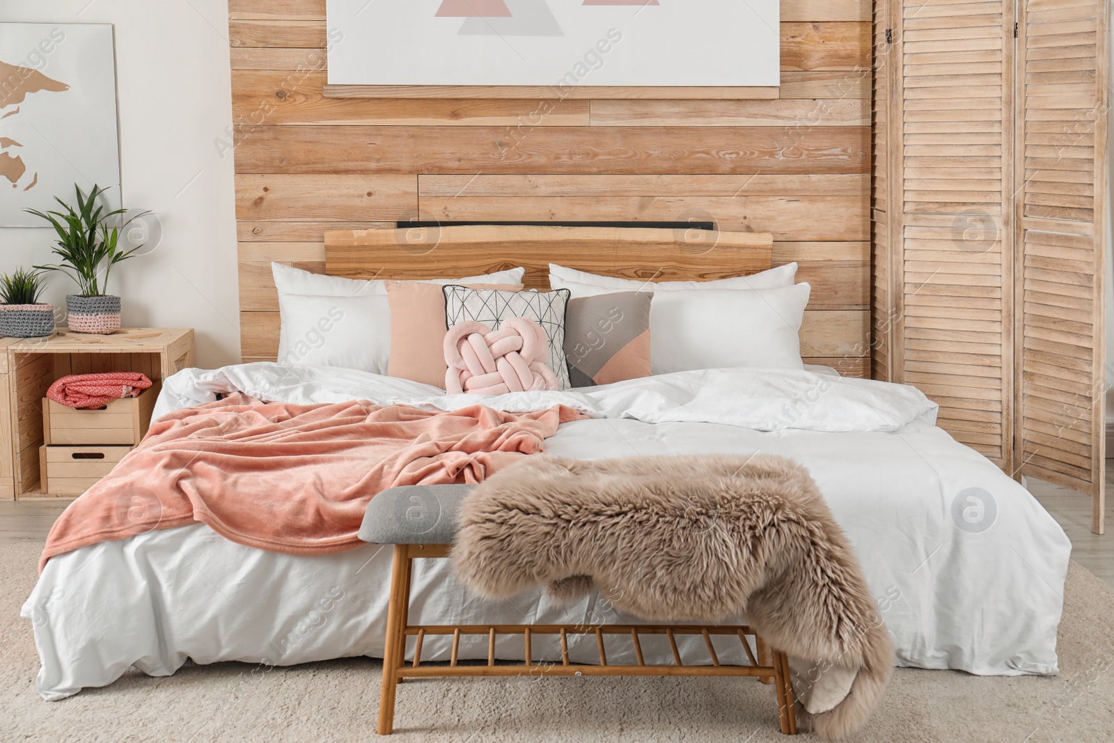 Photo of Stylish room interior with comfortable bed near wooden wall