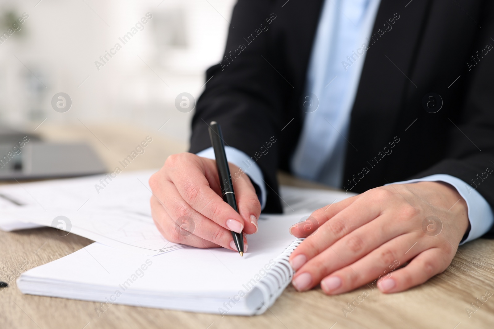 Photo of Secretary doing paperwork at table in office, closeup