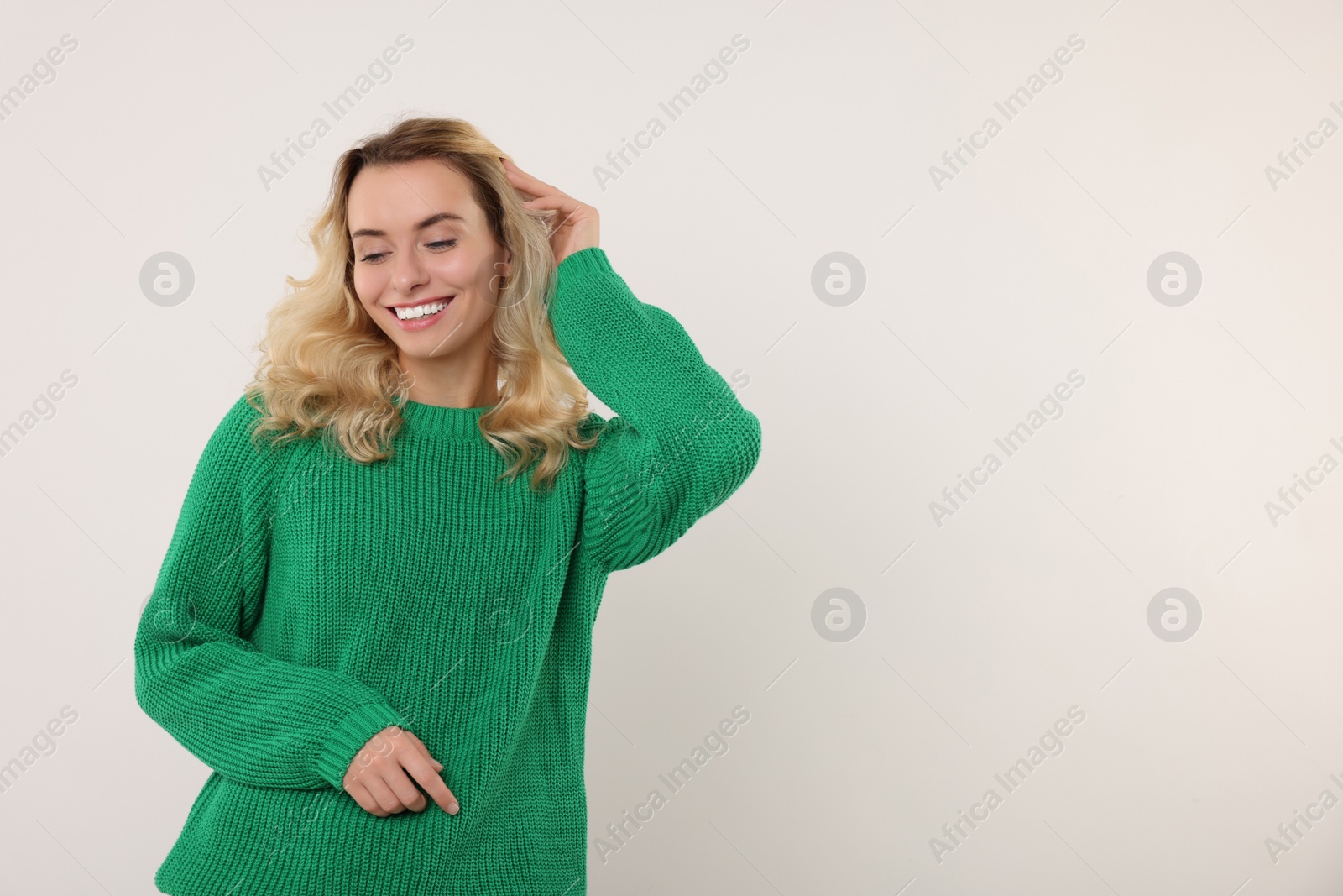 Photo of Happy woman in stylish warm sweater on white background. Space for text