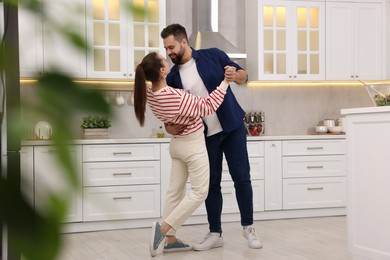 Photo of Happy lovely couple dancing together in kitchen