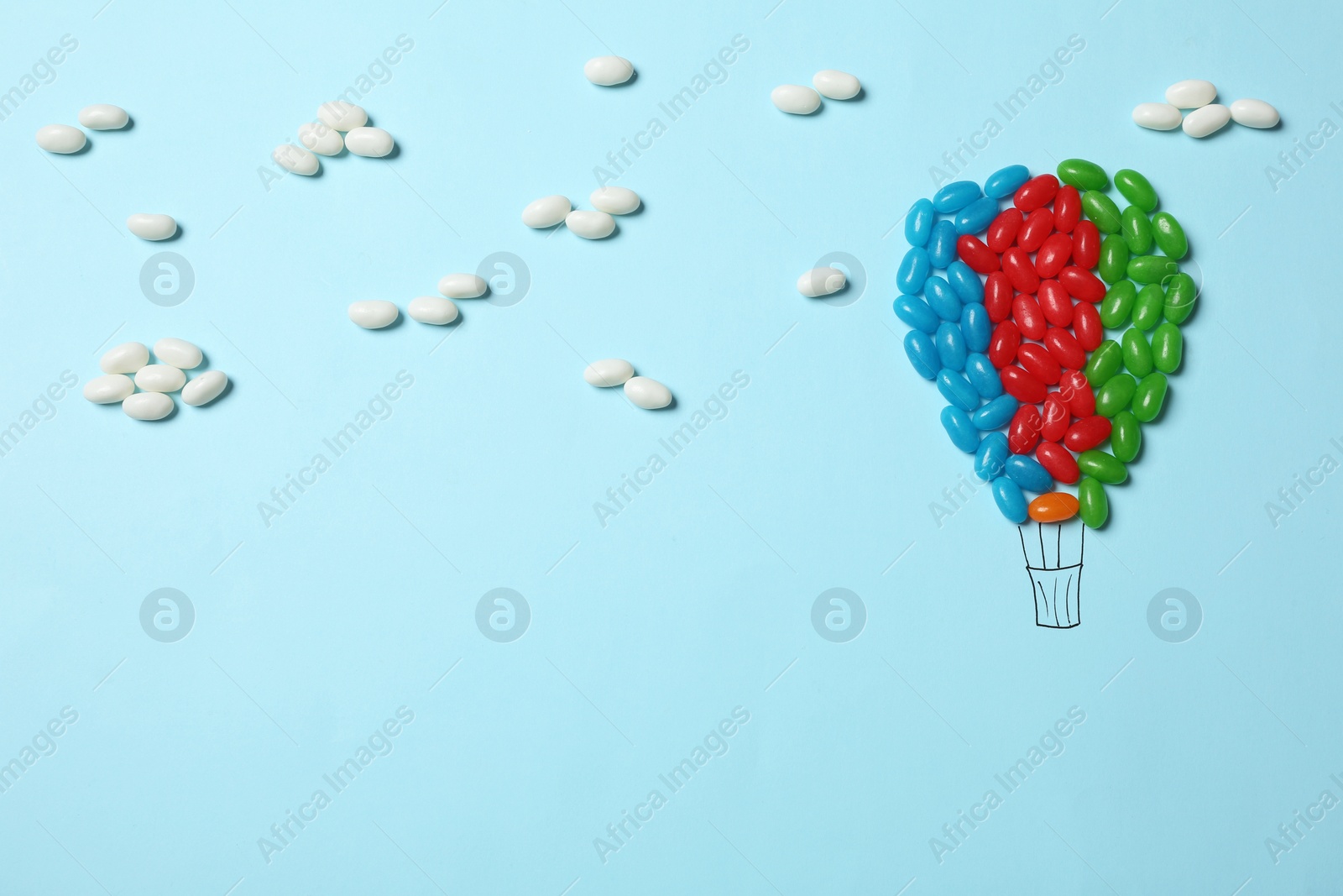 Photo of Bright jelly candies arranged as air balloon on color background, flat lay. Space for text