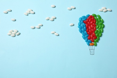 Bright jelly candies arranged as air balloon on color background, flat lay. Space for text