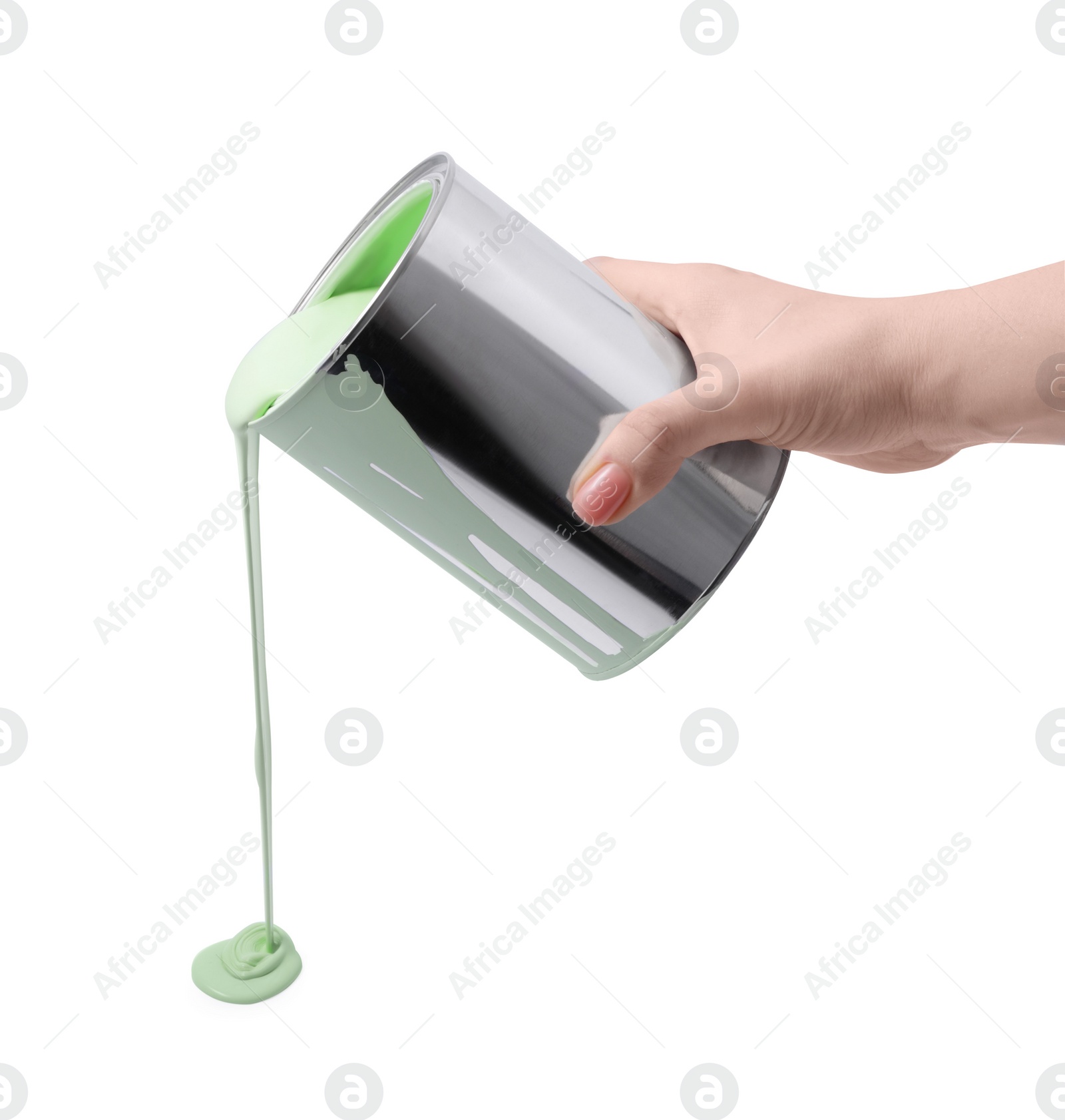 Photo of Woman pouring light green paint from can on white background, closeup