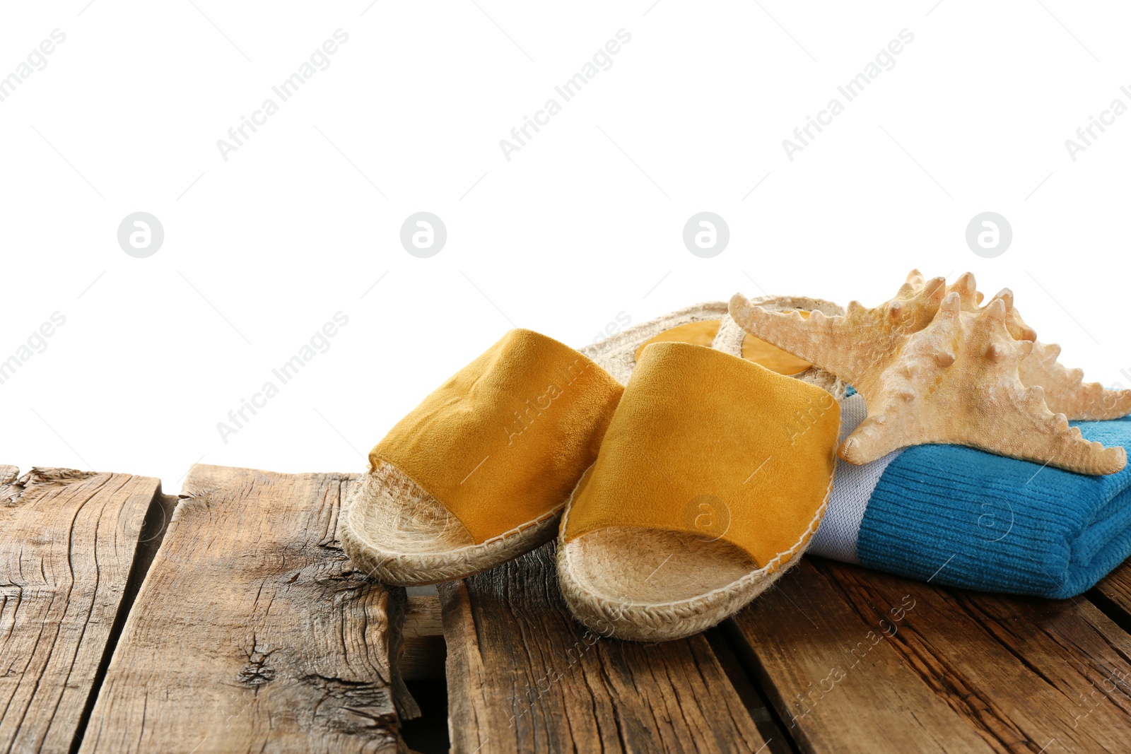 Photo of Towel, shoes and starfish on wooden table. Beach accessories