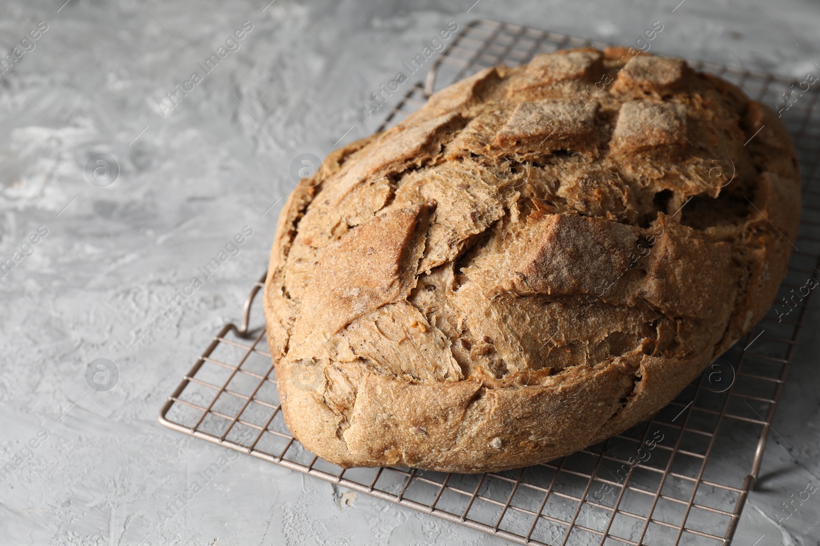 Photo of Freshly baked sourdough bread on grey table, closeup. Space for text