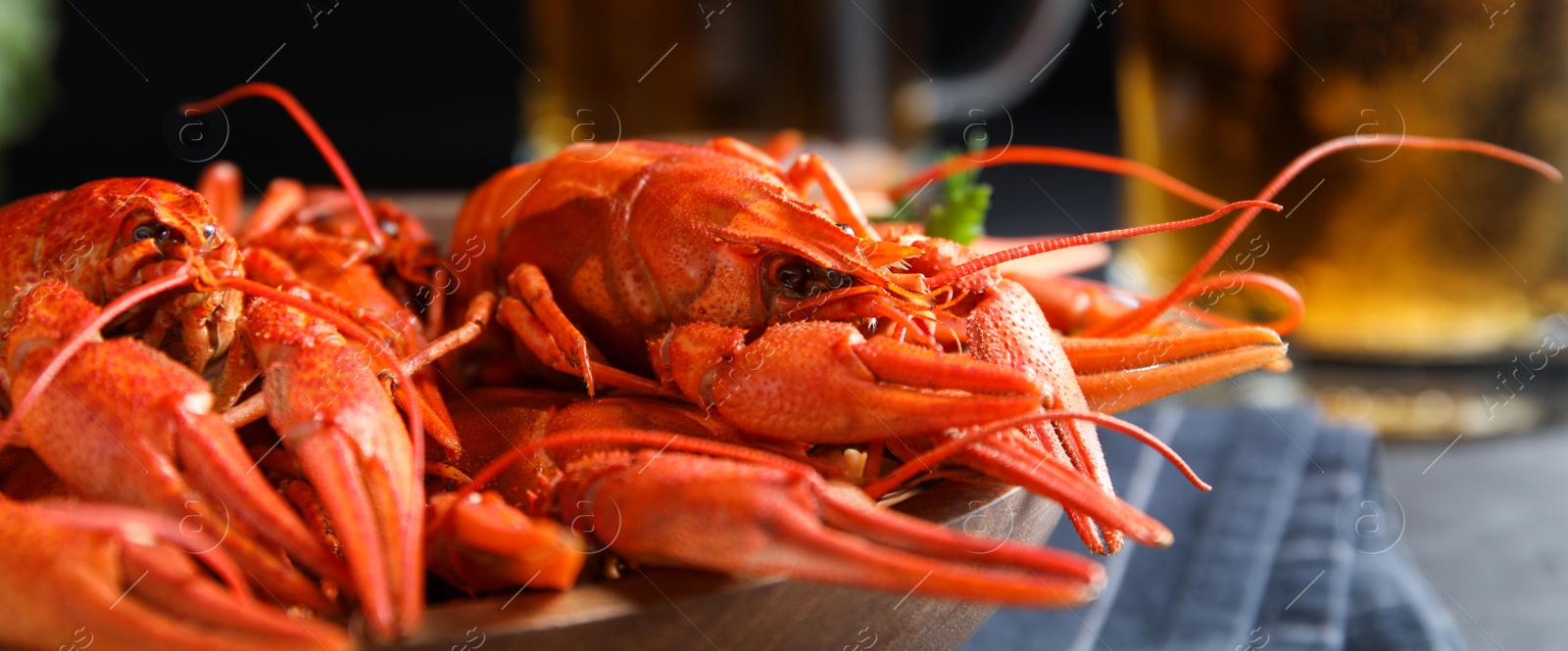 Image of Delicious red boiled crayfishes on table, closeup. Banner design