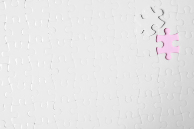 Blank white puzzle with separated piece on pink background, top view. Space for text