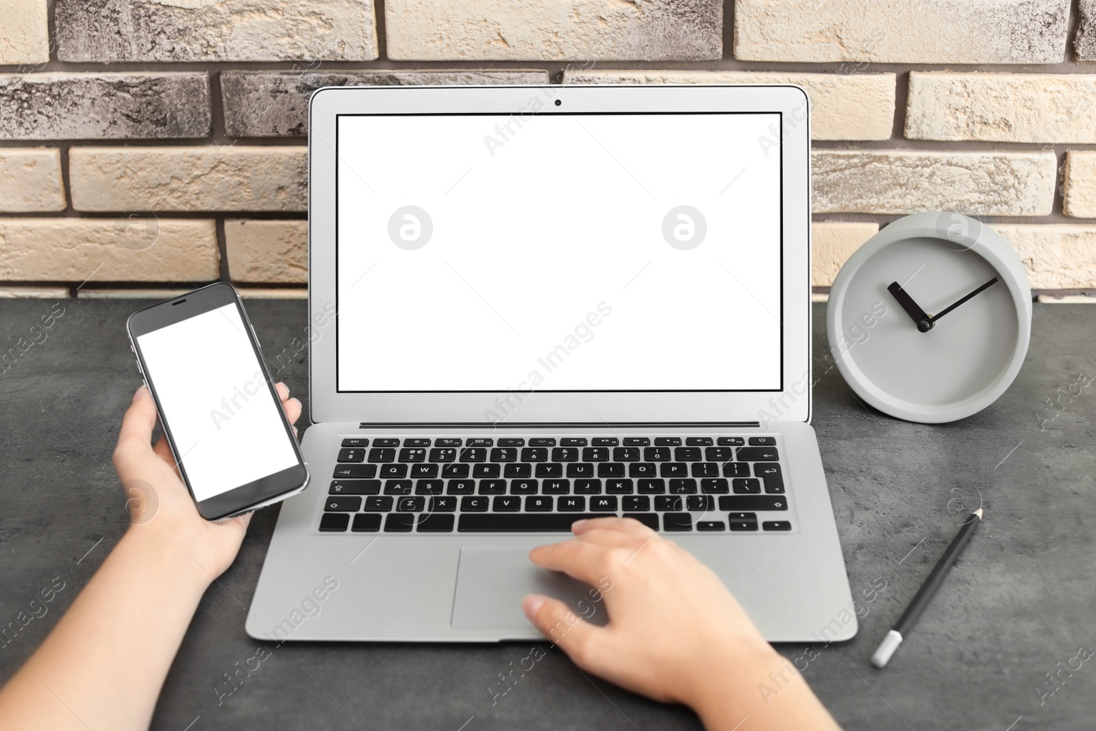 Photo of Woman working with laptop and smartphone at table. Mock up with space for text