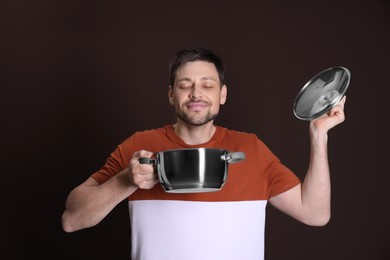 Photo of Happy man with pot on dark background