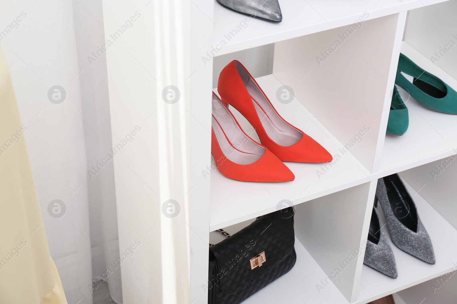 Photo of Shelving unit with shoes and purse, closeup. Element of dressing room interior