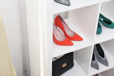 Photo of Shelving unit with shoes and purse, closeup. Element of dressing room interior