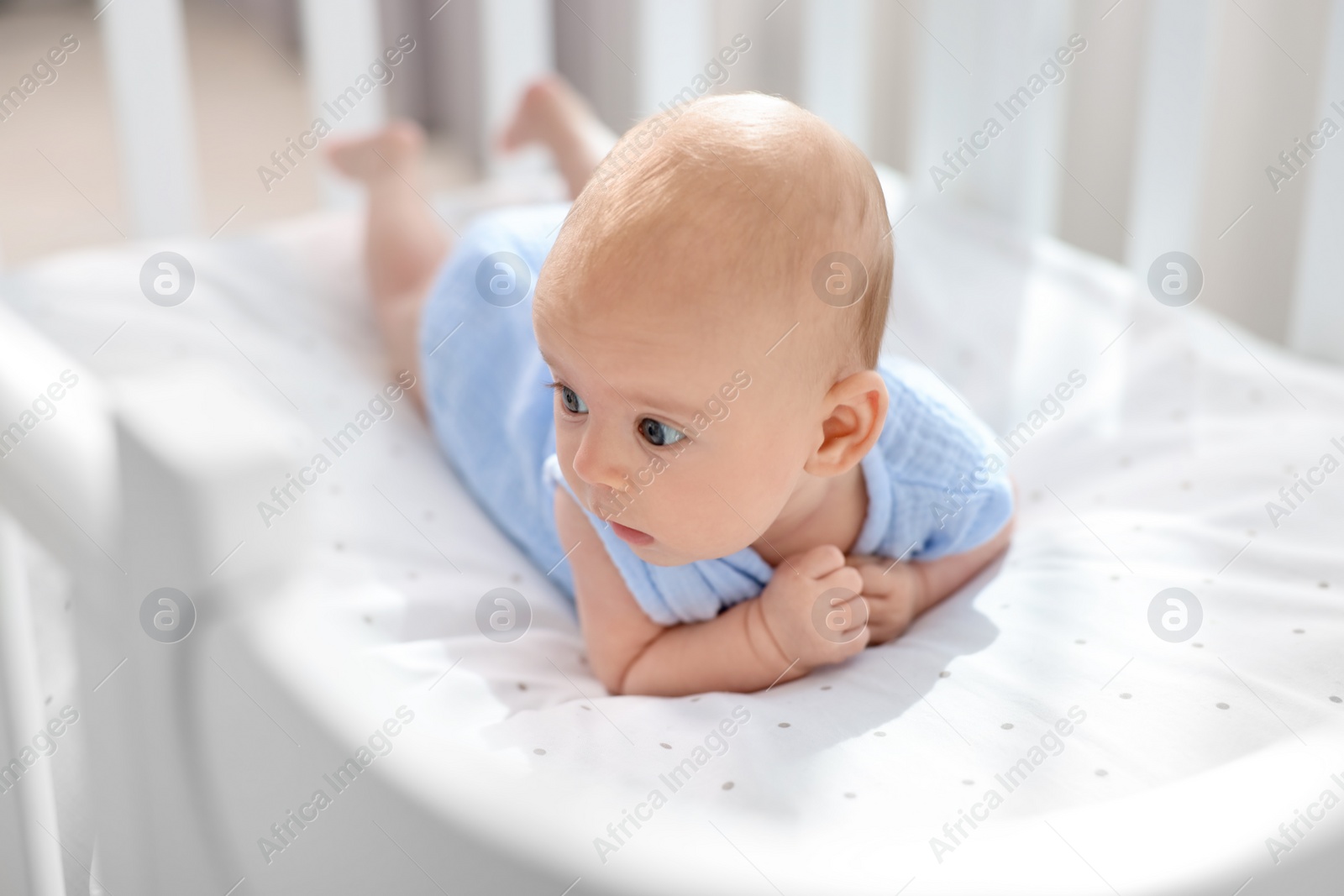 Photo of Cute little baby lying in crib at home