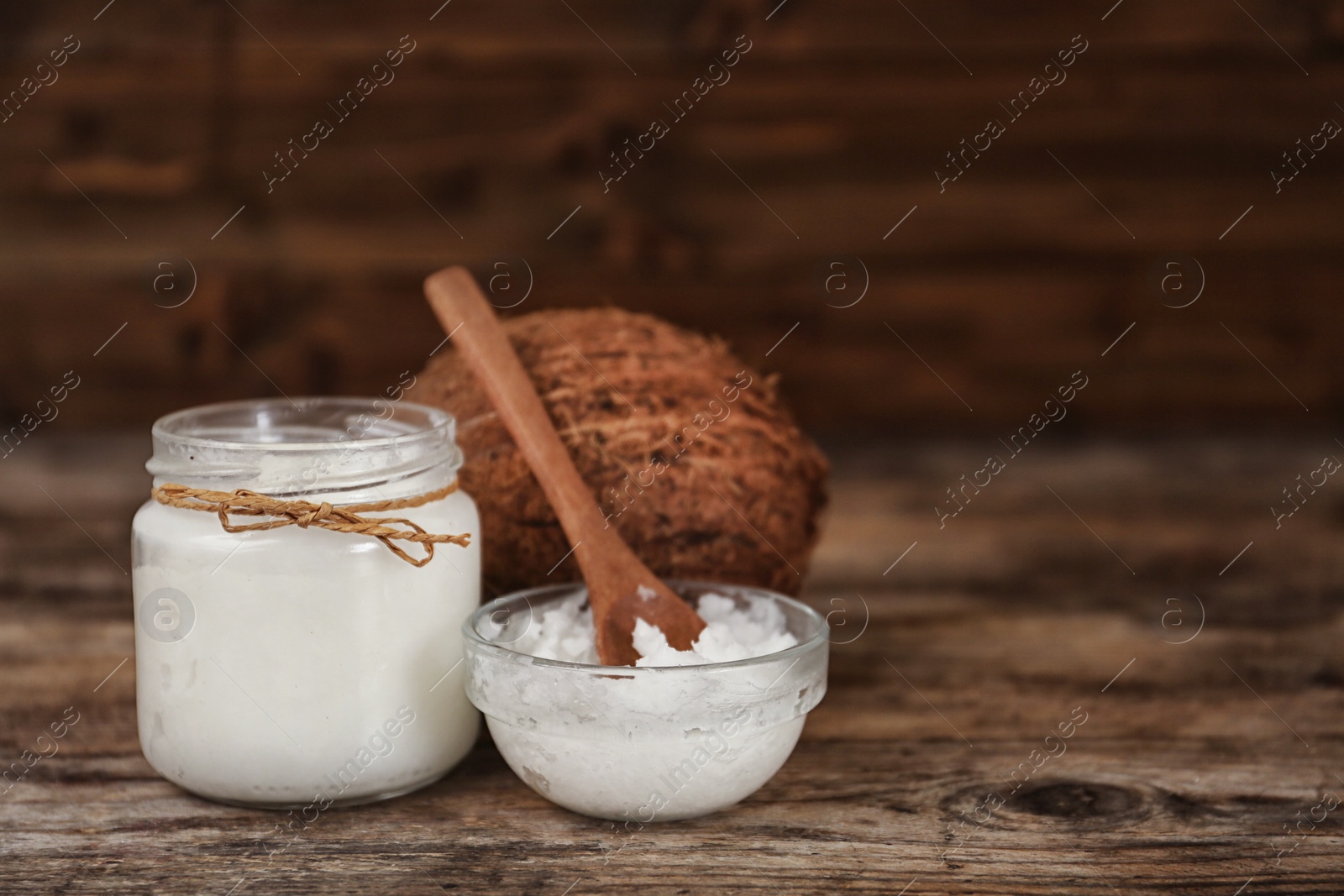 Photo of Fresh coconut oil on wooden table. Cooking ingredient