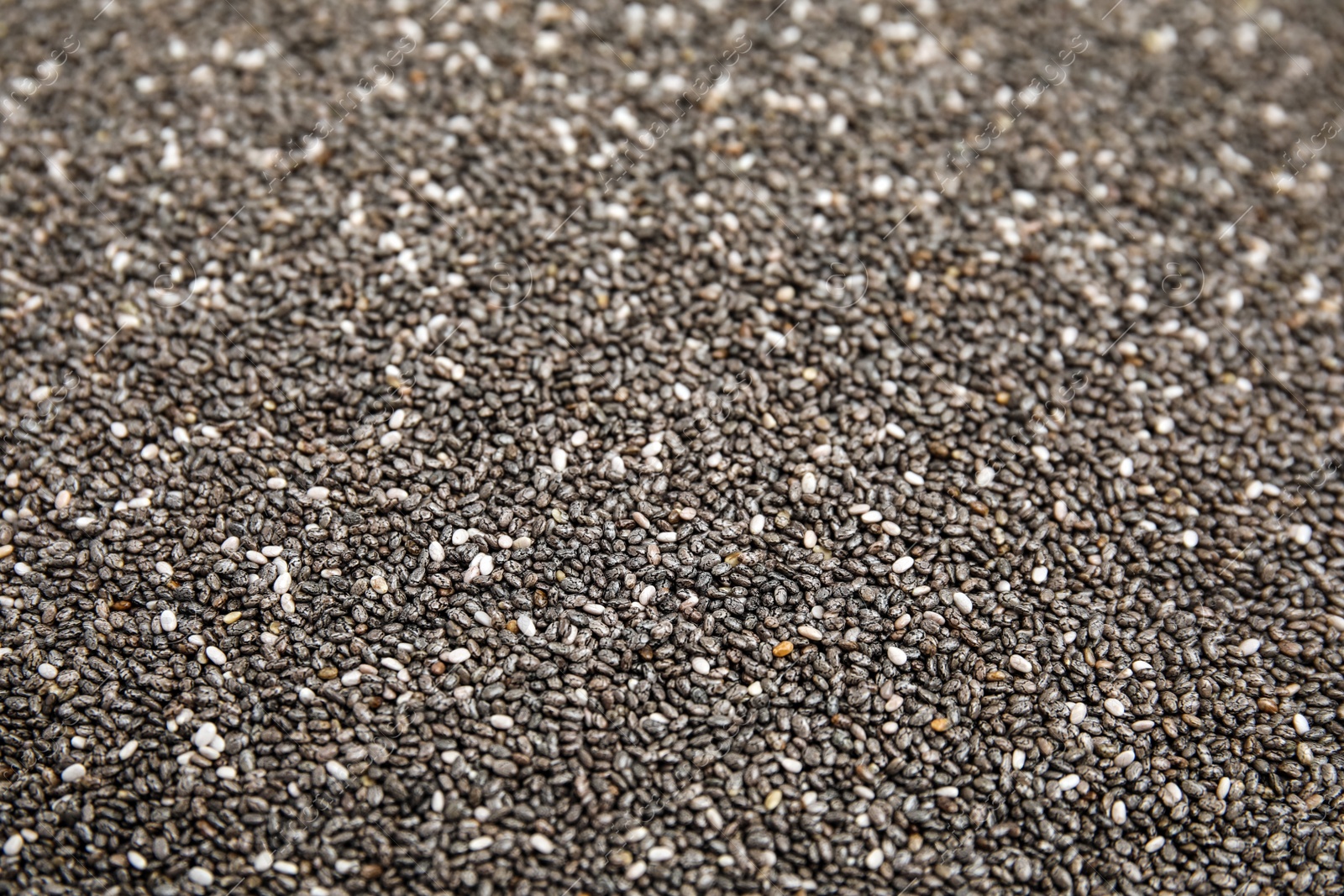 Photo of Heap of chia seeds as background, closeup. Veggie food