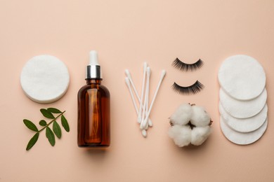 Photo of Cotton pads, swabs, flower, false eyelashes and makeup removal product on beige background, flat lay