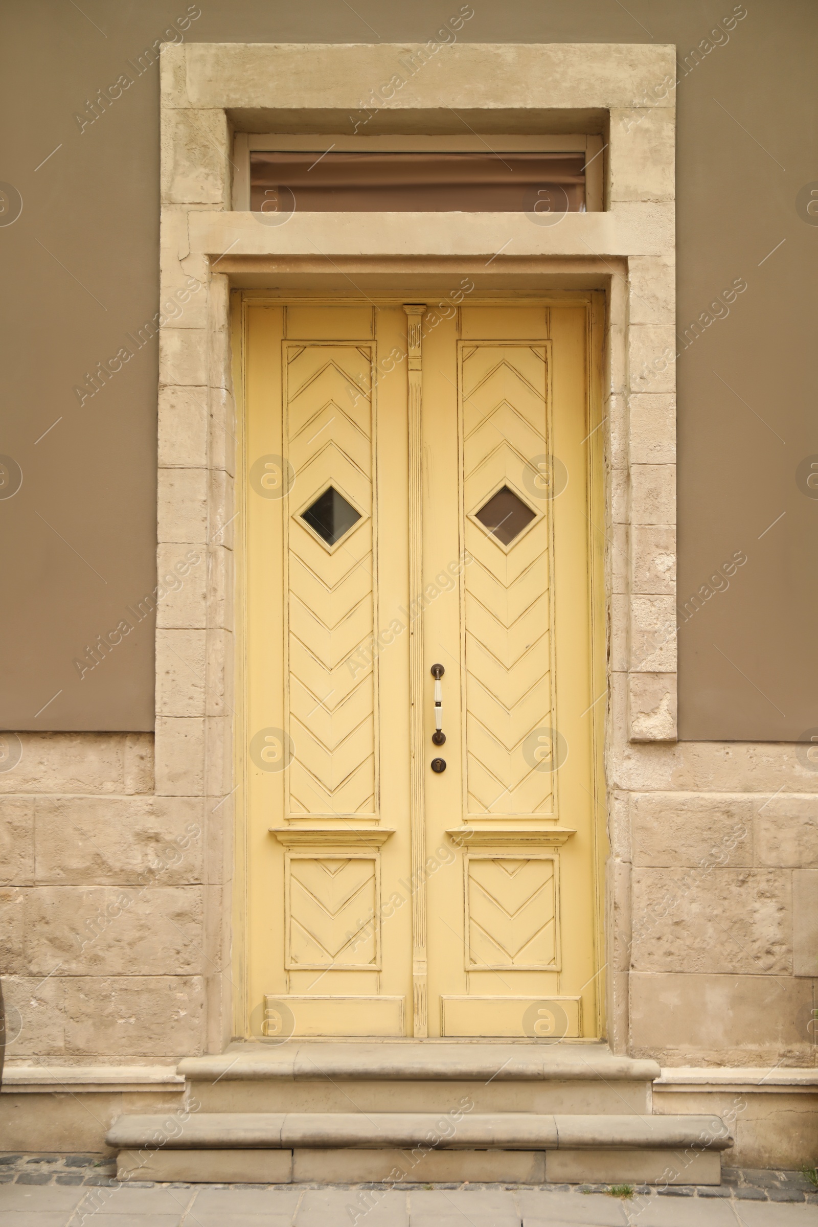 Photo of View of building with yellow wooden door. Exterior design