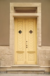 Photo of View of building with yellow wooden door. Exterior design