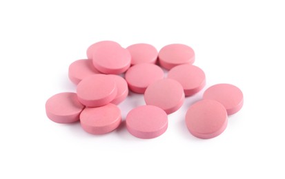 Pile of pink pills on white background