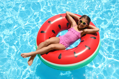 Photo of Girl on inflatable ring in swimming pool. summer vacation