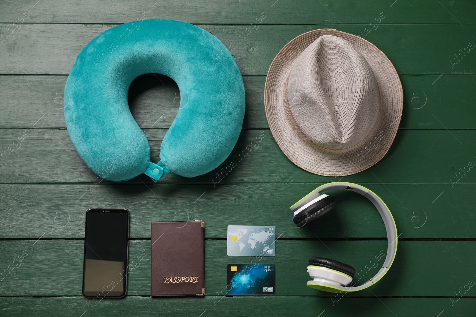 Photo of Flat lay composition with turquoise travel pillow and smartphone on green wooden background