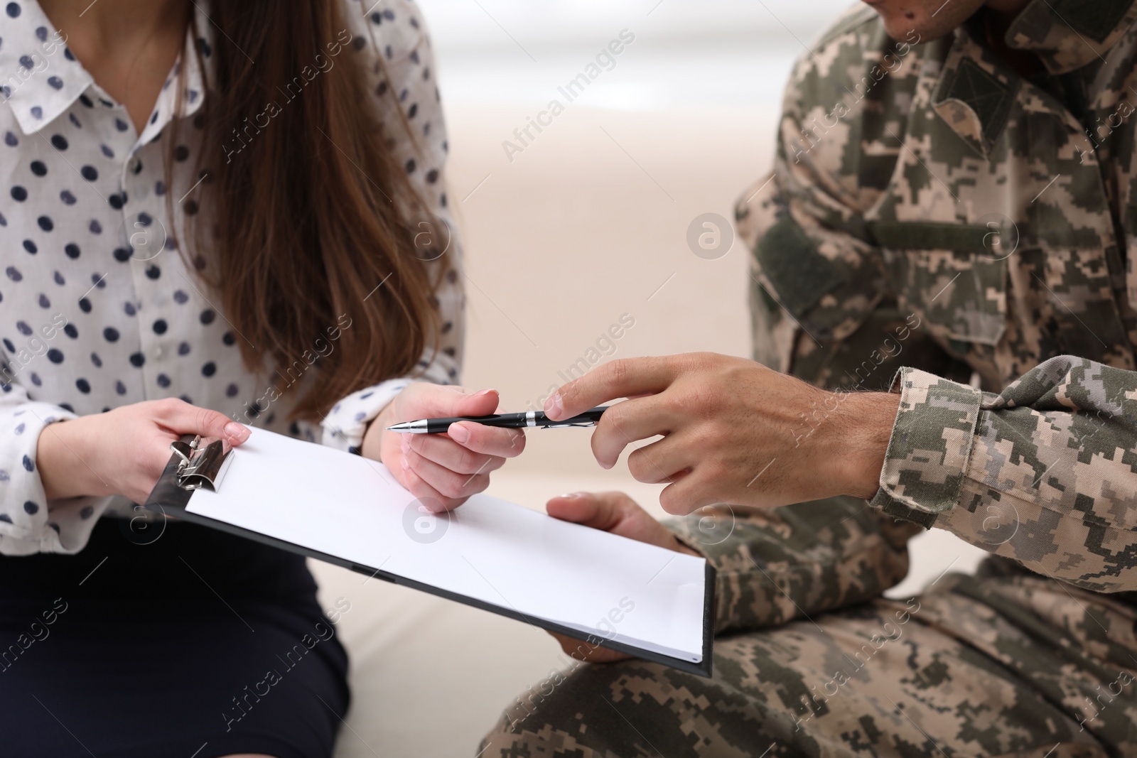 Photo of Male military officer filling form in psychotherapist office, closeup