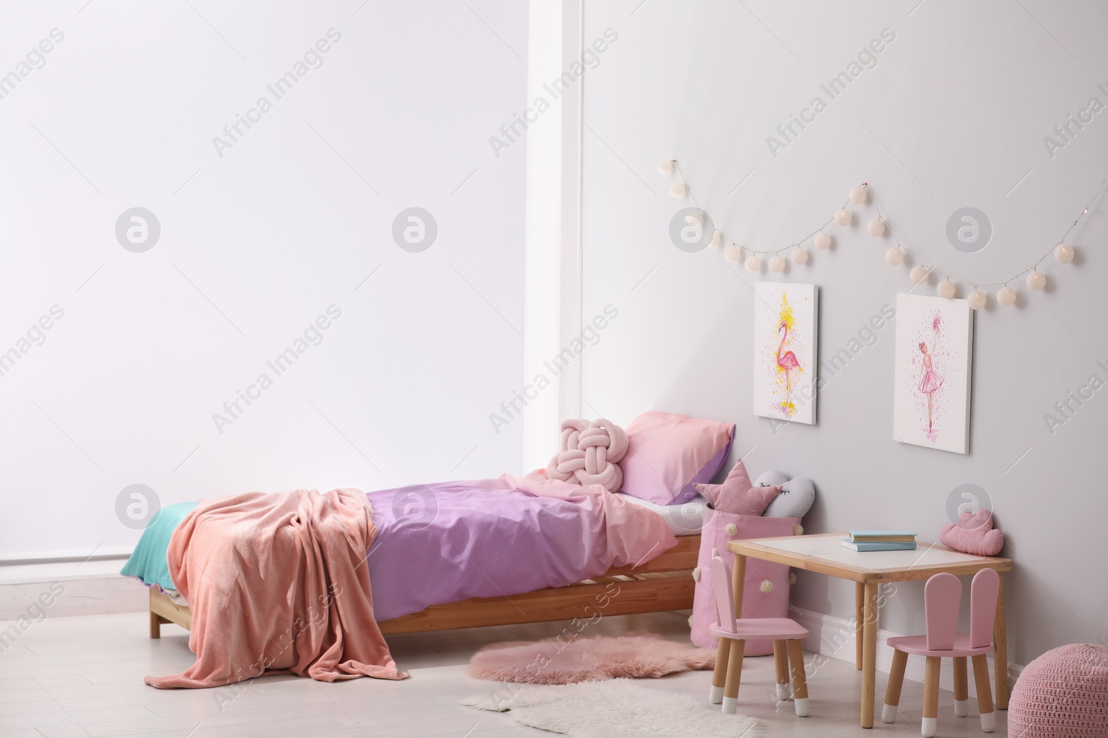 Photo of Comfortable bed with pink linens in children's room