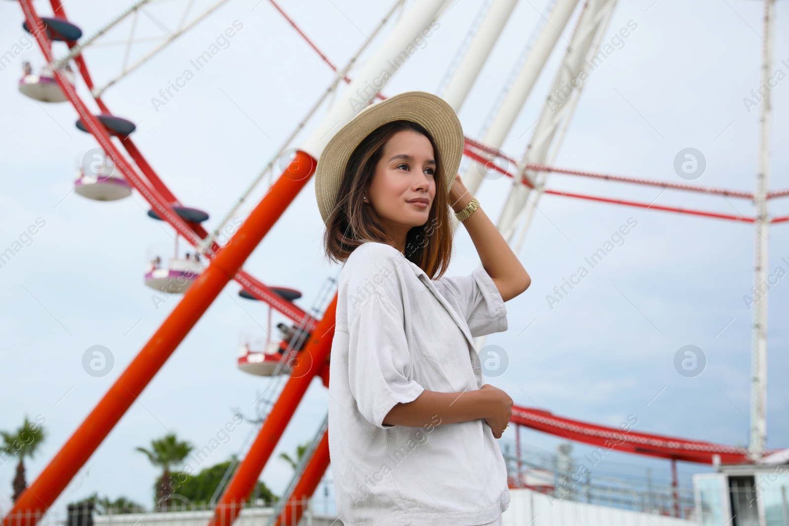 Photo of Beautiful young woman near Ferris wheel outdoors