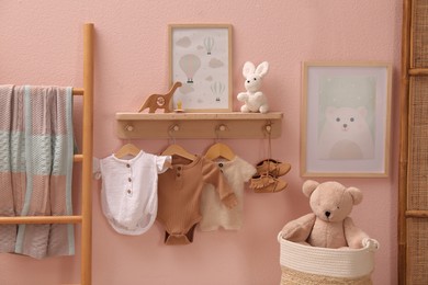 Photo of Cute baby clothes, toys and decorative elements in child's room