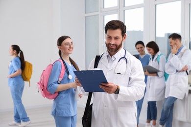 Photo of Smart medical student with clipboard in college hallway, space for text