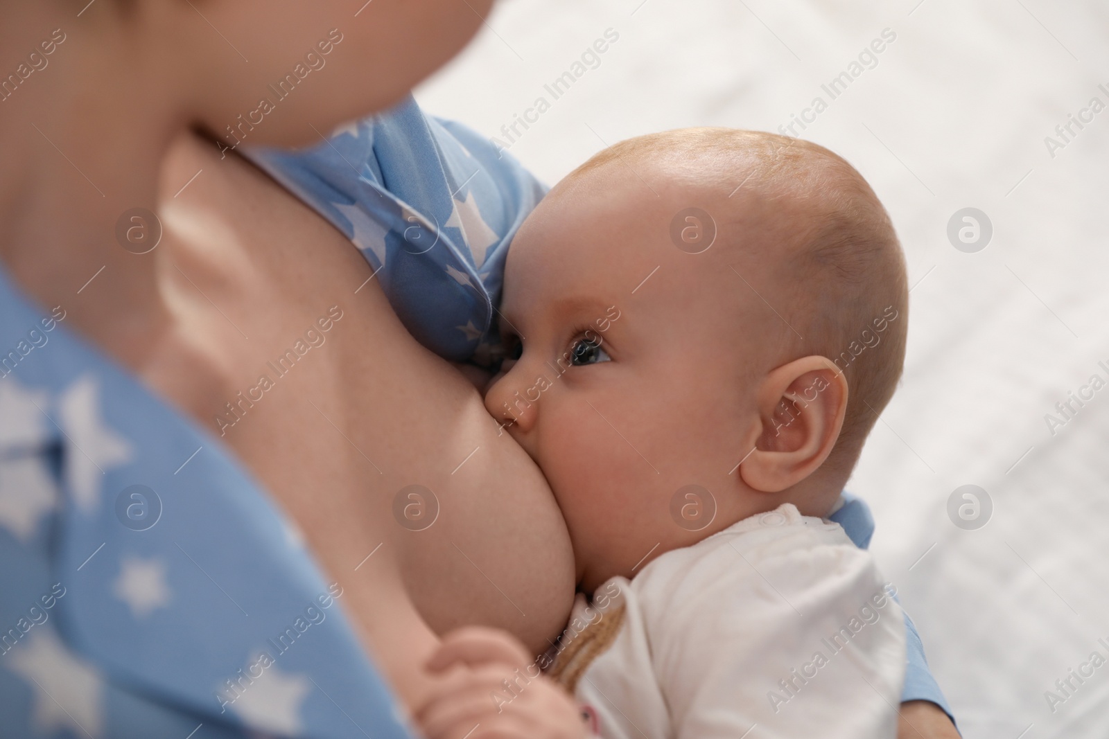 Photo of Young woman breast feeding her little baby, closeup